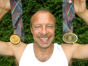 Steve Williamson, St. Thomas, holds the gold and bronze medals he claimed at the World Police and Fire Games earlier this month in Belfast, in high jump and 100 metre dash. Eric Bunnell/QMI Agency/Times-Journal