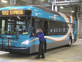Kingston Transit manager Jeremy DaCosta walks alongside one of the new buses for the express routes. (Michael Lea The Whig-Standard)