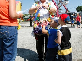 Five-year-old twins Haiden and Jarrett Blanchard-Scott are getting special balloons blown up before they enjoy free midway rides during the second annual Terrific Thursday at this year's Quinte Exhibition & Fall Fair in Belleville Thursday.