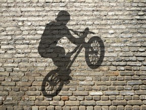 Shadow of a BMX style bike on a brick wall. (Fotolia.com)