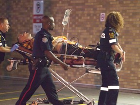 A stabbing victim is taken to hospital by paramedics late Friday night. (Manny Robrigues/Special to the Toronto Sun)