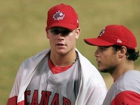 Canadian Justin Morneau talks with teammate Pierre Laforest at the end of a 2003 game versus Cuba. (Reuters)