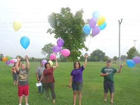 Members of Survivors of Suicide Loss release their balloons into the air Sunday at Miller Park in West Lorne after a walk in the community.