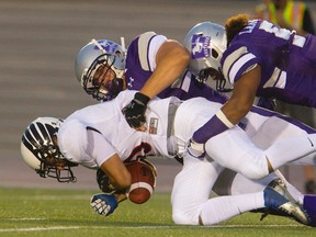 Westerns Mustangs Rupert Butcher and Beau Landry tackle Carleton?s Christian Battistelli during their Ontario university football game at TD Stadium Sept. 2. (MIKE HENSEN, The London Free Press)