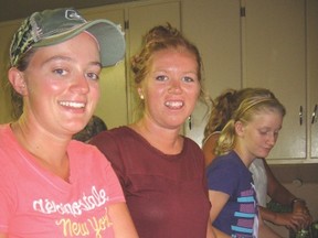 Meagan Higgins and Reba Jefferson slicing the cucumbers to make stackers.