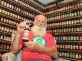 Allan Dodd holds a bottle of Ballard's Best, his favourite bottle of beer in a collection of more than 2,000 that fills his west-end home's basement.
Michael Lea The Whig-Standard