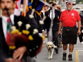 Capt. (Ret.) Medric Cousineau and his service dog, Thai, parade from the Belleville Armouries to Royal Canadian Legion Branch 99 Wednesday afternoon. Legionnaires and others escorted them.