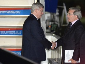 Canada's Prime Minister Stephen Harper (L) shakes hands with an official upon his arrival in St. Petersburg September 5, 2013. = REUTERS/Konstantin Salomatin/RIA Novosti/Pool