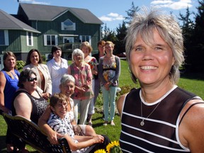 Sexual Assault Centre executive director Kim Charlebois, right, and staff gather outside their new Paths to Courage Healing and Retreat Centre north of Demorestville Thursday. From left: Carolann Sutherland, Gaye Feller, Elise Hineman, Deb Wessels, Lindsay Rogers, Nancy MacDonald, Gail Chiperzak, Jan Austin-Flowers, Kira Findlay and Stacey Trubridge.