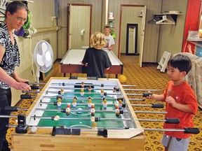 Vulcan’s daycare attended Friday, Sept. 5 the grand opening of the new Get-A-Way Youth Centre in the basement of the former fire station. Here, Trudy Klassen, alternate director of the daycare, plays foosball with Jihan Kim, 6.