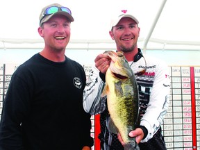 The 2013 champions of the Bassin’ for Bucks tournament in Souix Narrows, Mike Reid and Jeff Gustafson show off the 7.19-lb bass they caught on the third day of the fishing derby. See story page 5.