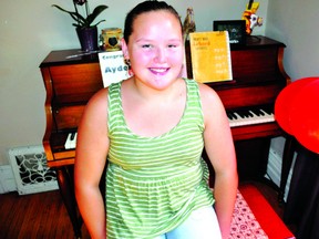 Ayden Alvis, 11, sits next to the piano she received from the Aeolian Hall’s 88 Keys to Inspiration program. The new program is a partnership between the Aeolian’s El Sistema Orchestra (a free music program at the hall) and D&S Pianos. Around 20 gently used pianos will be given to students over the next six months. CHRIS MONTANINI\LONDONER\QMI AGENCY