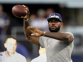 Miami Heat forward LeBron James throws a football before the start of the Dallas Cowboys' game against the New York Giants in Arlington, Tex., September 8, 2013. (REUTERS/Mike Stone)
