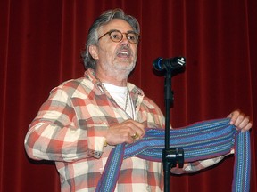 Award-winning author David Bouchard holds up a Metis sash as he spoke to students at Wallaceburg District Secondary School on Tuesday, September 10, 2013 about learning to love to read.