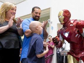 Carter Robbins, 7, meets his favourite superhero, Iron Man, as his parents Jeannette and Anthony watch on after his final radiation treatment at the London Regional Cancer Program at London Health Sciences Centre in London on Tuesday. A surgeon nicknamed the youngster Iron Man for his stamina. (CRAIG GLOVER, The London Free Press)