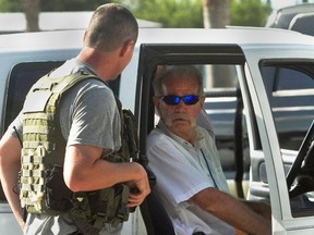 Pastor Terry Jones,  talks to a member of the Polk County Sheriff's Department as he sits in his vehicle prior to his arrest after being pulled over while travelling on State Road 37 in Mulberry, Florida September 11, 2013. (REUTERS/Michael Wilson/The Lakeland Ledger )
