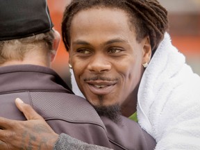 Saskatchewan Roughrider Dwight Anderson, a former Calgary Stampeder, embraces a Stamps employee after a walk-through practice at McMahon Stadium Aug. 8, 2013. (Lyle Aspinall/Calgary Sun/QMI Agency)