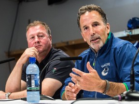 Vancouver Canucks coach John Tortorella (right) and general manager Mike Gillis speak to the media during training camp at Rogers Arena in Vancouver, B.C. Wednesday September 11, 2013. (CARMINE MARINELLI/QMI Agency)