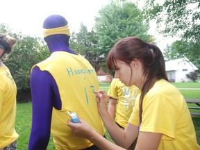 Matt Hooghiem, gets his name placed on his shirt by Kristen Kovacs, right, at the West Elgin Secondary School Transition Camp at Pearce Williams Christian Centre Thursday.