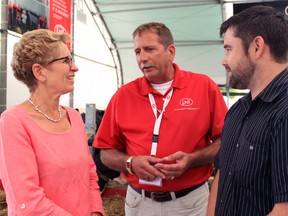 Premier and Agriculture Minister Kathleen Wynne speaks to a Lely employee at the Dairy Innovation Centre at Canada's Outdoor Farm Show on Thursday afternoon in Woodstock. CODI WILSON/ Sentinel-Review