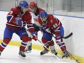 Kingston Voyageurs Adam Brady (19) and Charles Dube get to the puck ahead of a Wellington player during Ontario Junior Hockey League action at the Invista Centre Thursday. (Ian MacAlpine/The Whig-Standard)