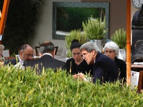 U.S. Secretary of State John Kerry (second from right) and Russian Foreign Minister Sergei Lavrov (back to camera) negotiate ongoing problems in Syria, while seated with their senior aides by the swimming pool at a hotel in Geneva September 14, 2013. (REUTERS/Larry Downing)