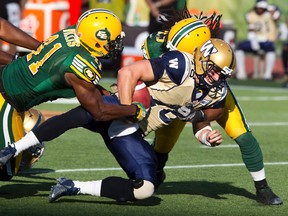 Edmonton Eskimos Odell Willis #41, left, helps Damaso Munoz #45, right, sack Winnipeg Blue Bombers quarterback Justin Goltz #18 during first half CFL action at Commonwealth Stadium in Edmonton, Alta. on  Saturday, September 14, 2013.  Amber Bracken/Edmonton Sun/QMI Agency