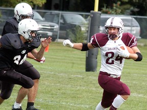 Wallaceburg Tartans running-back Marc Kellett outruns a pair of McGregor defenders during the Tartans opening game held in Wallaceburg on Friday. The Tartans won the game 30-6.