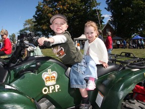 Easton Vanhecke, 3, is ready to take his little sister Paisley, 18 months, for a ride on an OPP ATV at the Milford Fair on saturday afternoon. The OPP both was one of two dozen set up around the Milford Fairgrounds for the annual one-day fair.