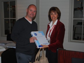 David Fife, vice principal of Mitchell Hepburn Public School in St. Thomas, receives a binder containing information and a cheque from program director Charlotte McDonald of the Elgin Community Nutrition Partnership. The cheque was part of a $227,132 funding allocation for nutrition programs in schools across Elgin county and St. Thomas. (Ben Forrest, Times-Journal)