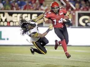 Stampeders' Matt Walter swats Ticats' Rico Murray out of the way during last Friday's game at McMahon Stadium in Calgary. Hamilton lost the game and will look to rebound when they travel to Moncton, N.B. to face the Montreal Alouettes. (Lyle Aspinall/QMI Agency)