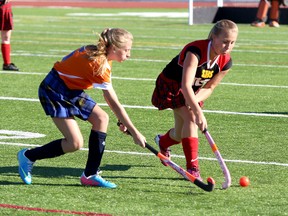 Bayridge Blazers’ Norah Gibson, left, battles for the ball with Sydenham Golden Eagles’ Emily Moslinger during a high school field hockey game at Caraco Home Field on Tuesday. (Ian MacAlpine/The Whig-Standard)