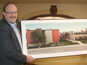 Ridgetown College director Ken McEwan poses with a photo of the D.J. Pestell Student Service and Alumni Centre. The $3.5 million facility opened this month. The building is among the infrastructure improvements being carried out at the growing campus.