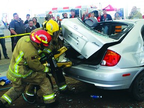 Kenora Fire and Emergency Services Cpt. Larry Cottam and a firefighter use ‘the spreader’  during a vehicle extrication demonstration at Family Safety Night on Tuesday, Sept. 17. The spreader is one piece of the Jaws of Life equipment used to rescue people trapped inside crashed vehicles