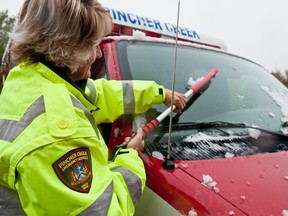 EMT Jennifer Fisher-Sundberg cleans the snow off of her ambulance after Pincher Creek's freak late summer snowfall. Bryan Passifiume photo/QMI Agency