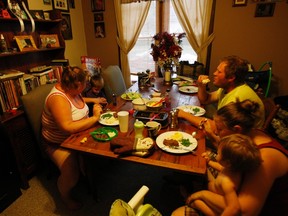 (Clockwise, L-R) Katie Busker, 30, sits with her son, Austin Spiker, at the home she shares with her brother-in-law Dustin Gibbs, her sister, Lauren Gibbs, and the Gibbs' daughter, Johnnalyn, as the family shares dinner together in Independence, Iowa July 5, 2011. (REUTERS/Jessica Rinaldi)