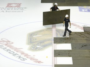 Members of the Budweiser Gardens crew remove boards from the ice surface, revealing the London Knights logo at centre ice, at the downtown home of the junior hockey team in London on Thursday September 19, 2013.  The Knights play host to the Plymouth Whalers as they open their regular season against the Michigan team at the Gardens. (CRAIG GLOVER, The London Free Press)