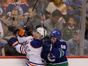 Brad Hunt crashes into the boards with Canucks’ Brendan Gaunce during Wednesday's game in Vancouver. (Carmine Marinelli, QMI Agency)
