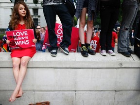 A protester holds up a placard during a demonstration against Russia's anti-gay legislation opposite Downing Street in London, September 3, 2013. REUTERS/Andrew Winning