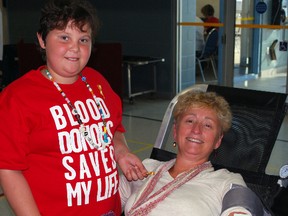 Cancer survivor Sarah Berger, left, gives a gold pin to blood donor Nancy Maunu at a blood donor clinic at the Timken Centre in St. Thomas on Wednesday. Berger received life-saving blood transfusions during her cancer treatment and gave pins as a way of thanking donors for helping save more lives.