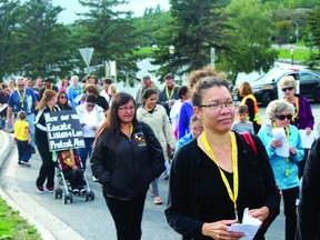 alan  s. hale/Daily Miner and News 
Take Back the Night marchers head out from the Whitecap Pavilion as police close traffic through the roundabout, Thursday evening.