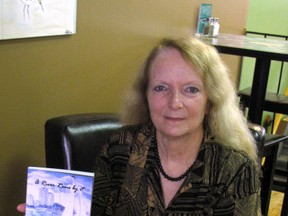Margaret Bird, editor and contributing author of "A River Runs By It," holds a copy of the new book. There will be a special book launch event on Sunday, October 6 from 2 to 5 p.m. at the Imperial Theatre. (LIZ BERNIER, The Observer)