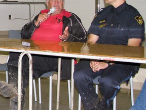 IPM 2013 Chair Bert Vorstenbosch (left), clad in rubber boots, addresses the media along with OPP Const. Jamie Stanley during an impromptu press conference held Saturday, Sept. 21 at the Mitchell & District Community Centre.