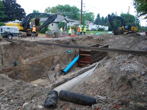 Crews move in to repair broken water main Saturday morning on Centennial Ave. The 18-inch main supplies 70% of the city's water and the break about 7:30 a.m. dropped water pressure throughout the city -- in some homes, to a trickle. Ben Forrest/QMI Agency/Times-Journal