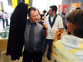 Graduate Matthew MacNeil tries on his gown as Fleming College celebrates its first graduating class of Community Integration through cooperative Education (CICE) on June 6, 2013 at Fleming College in Peterborough, Ont. The CICE program is a two-year Ontario College Certificate program, which offers a combination of academic courses and cooperative education opportunities open to adults with developmental disabilities, Autism Spectrum Disorder, mild intellectual disabilities or brain injury. (Clifford Skarstedt/QMI Agency)