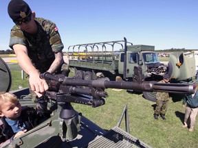 Master Corporal Adam Dart (upper) goes over the operation of a mounted CP 7.62 mm General Purpose Machine Gun with four-year-old Clayton Joliffe (lower) last Saturday during the Canadian Harvard Aircraft Association’s annual Wings & Wheels Fly Day. Jeff Tribe/Tillsonburg News