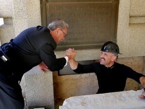 Stone mason Steve Lalancette (r) shakes hands with Speaker Gene Zwozdesky after placing in the new time capsule during the Alberta Legislature Centennial Time Capsule Ceremony in Edmonton, Alberta on Wednesday, September 25, 2013.  Perry Mah/ Edmonton Sun