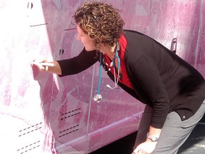 Chatham-Kent Community Health Centre nurse practitioner Lisa Babcock signs the Canadian Breast Cancer Foundation's pink tour bus on Sept. 26. The Canadian Breast Cancer Foundation's Pink Tour was in town to provide information about how people can reduce their risk of breast cancer. People could get information through a series of interactive displays on the 46-foot pink tour bus.
