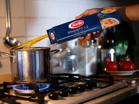 A man throws Barilla spaghetti into boiling water as he cooks at his home in Rome September 27, 2013. Guido Barilla, chairman of the world's leading pasta manufacturer, prompted calls for a consumer boycott on Thursday after telling Italian radio his company would never use a gay family in its advertising.  (REUTERS/Max Rossi)