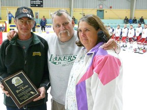 Submitted photo
Paul Zoula, left smiles, as he was recognized for his 25 years of volunteering with the Wallaceburg Lakers hockey team during a recent home game. Wallaceburg Lakers president Pat Henderson presents Zoula with a plaque, while Zoula's wife Pat Zoula looks on.